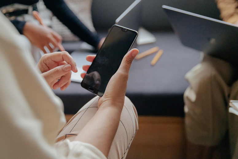 Businessperson Using a Smartphone in a Meeting